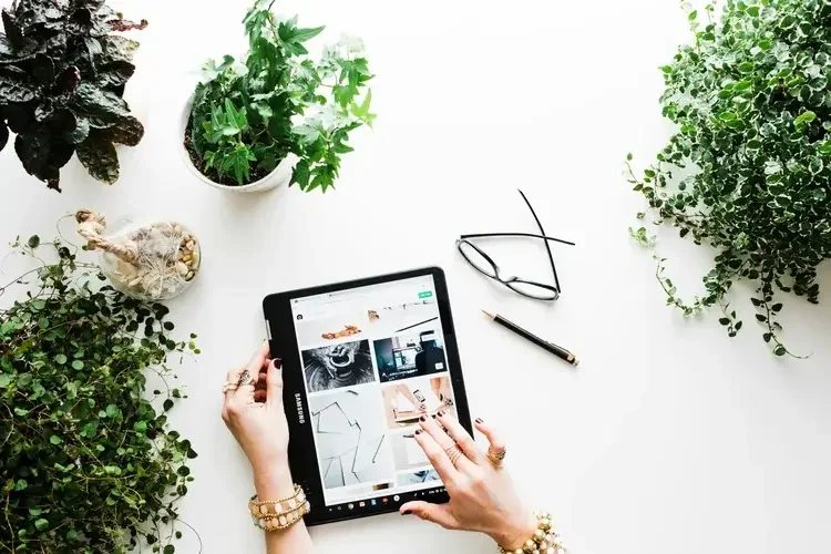 Interior designer reviewing design ideas on tablet with plants and workspace setup for home renovation planning