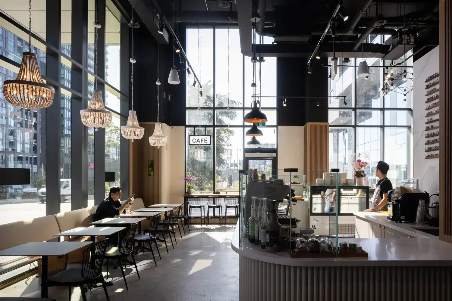 Modern café interior design in Toronto with high ceilings, large windows, and contemporary lighting creating an inviting atmosphere