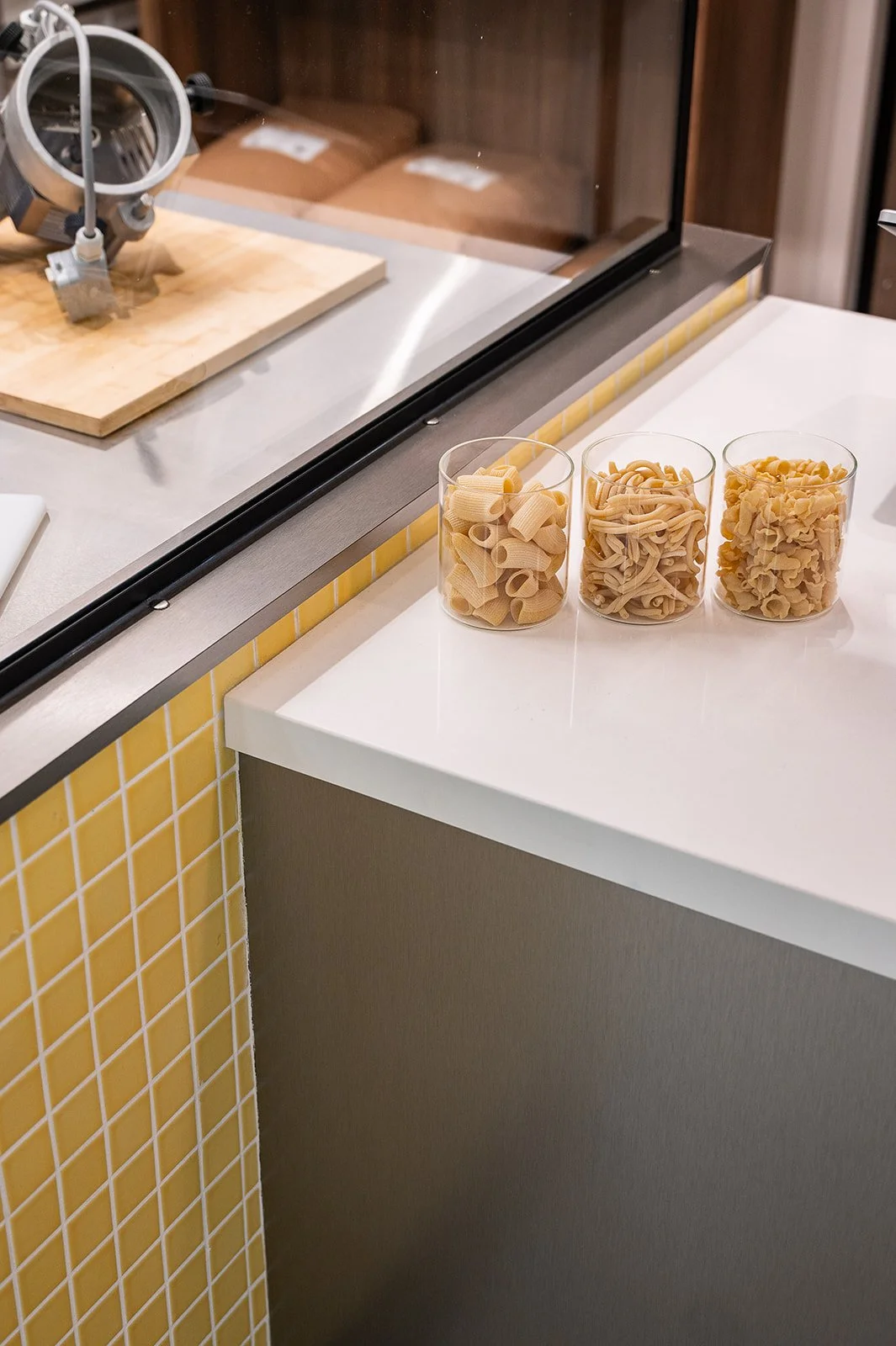 dry pasta noodles on counter with yellow mosaic tile