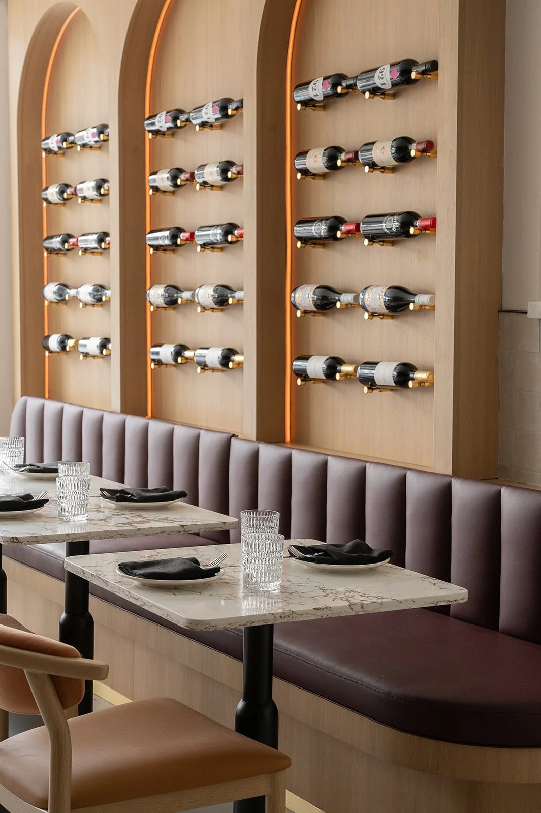 Italian restaurant banquette with wine bottle display above