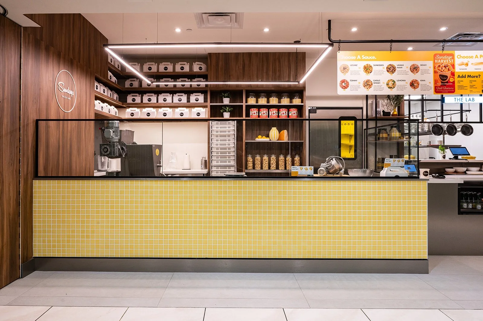 Yellow mosaic counter front with sleek linear lighting above