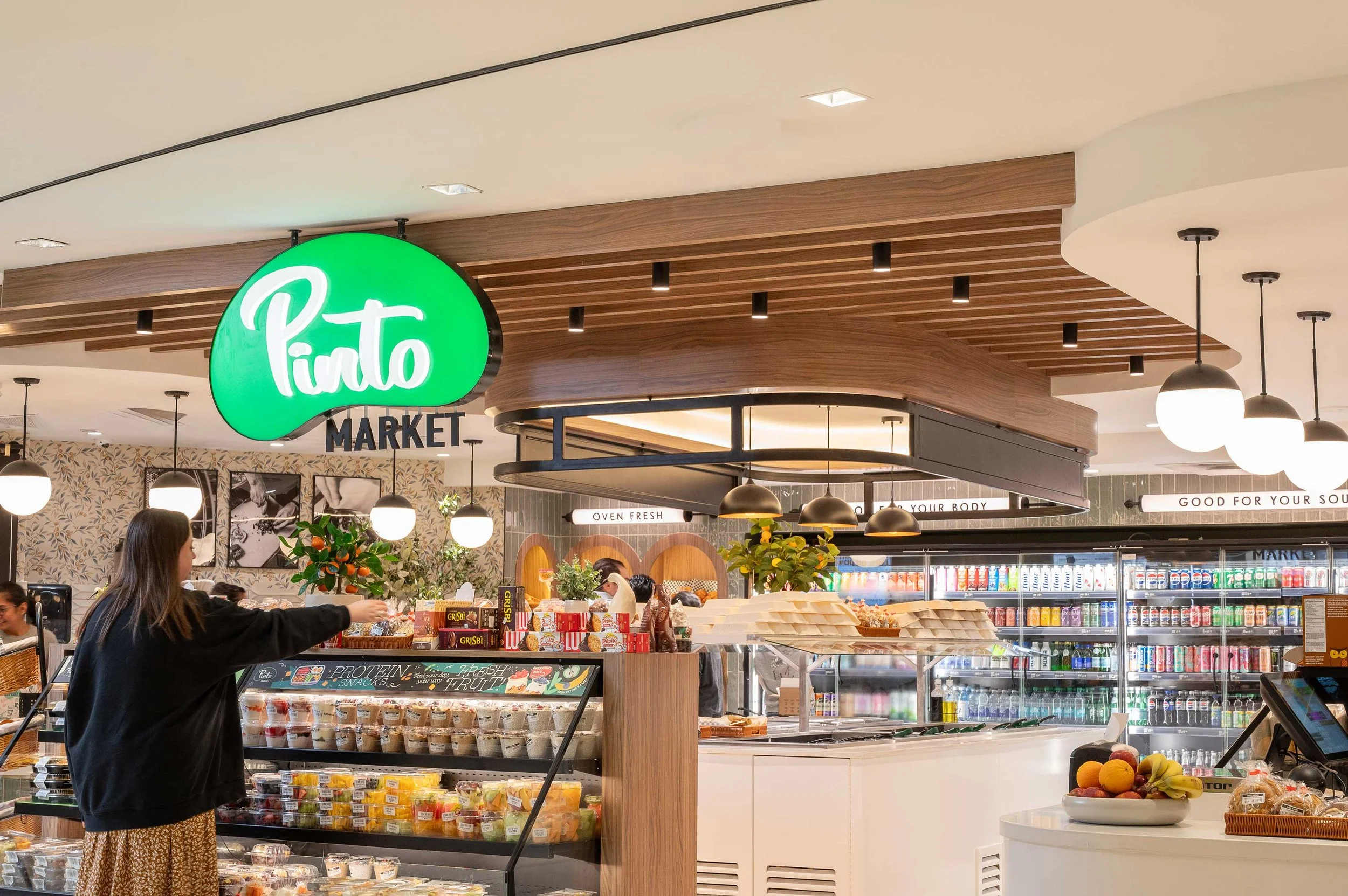 Pinto Market illuminated storefront signage attached to walnut wood slat ceiling detail