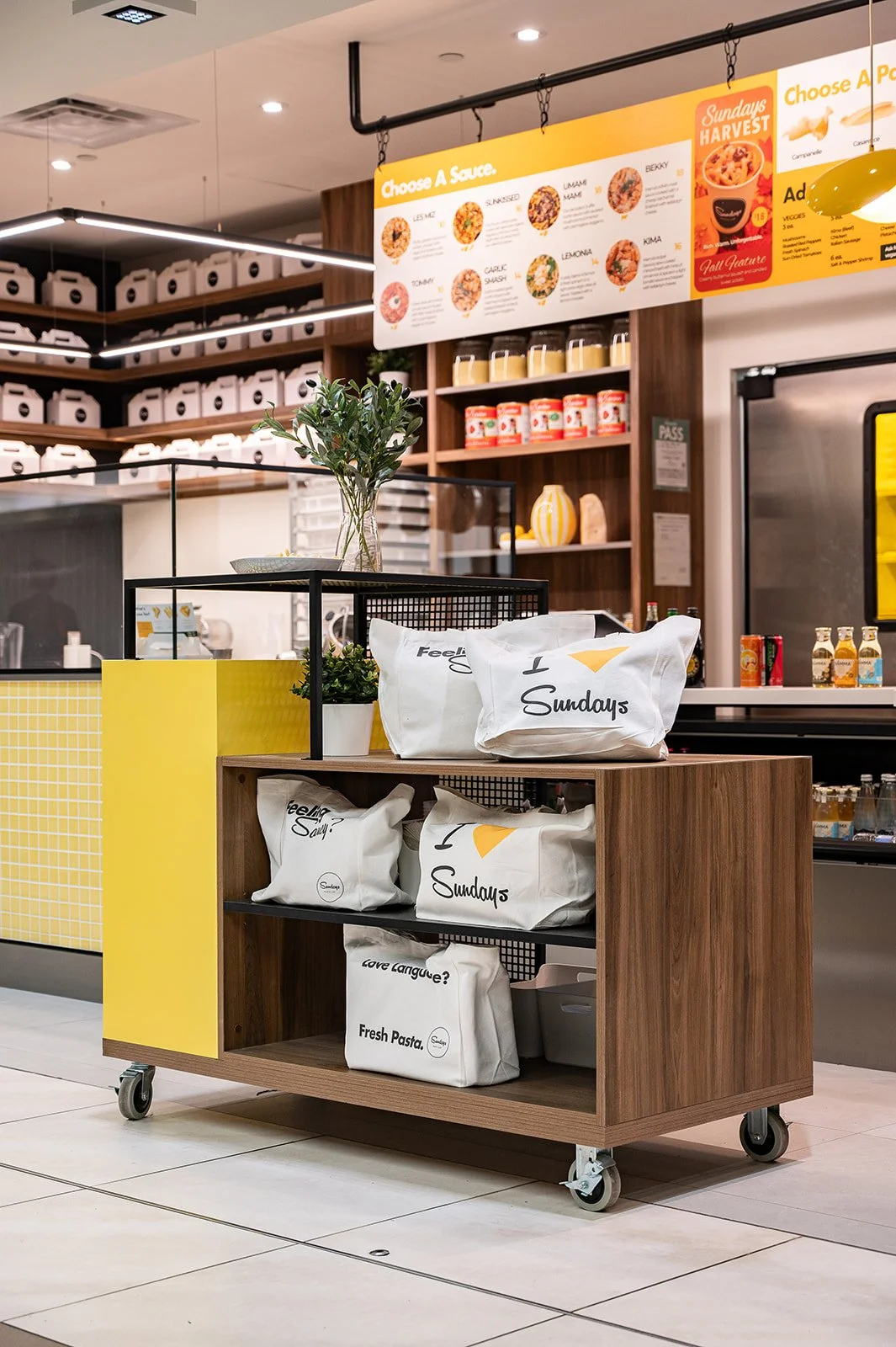 Pasta bags on a mobile cart with pops of yellow and walnut wood