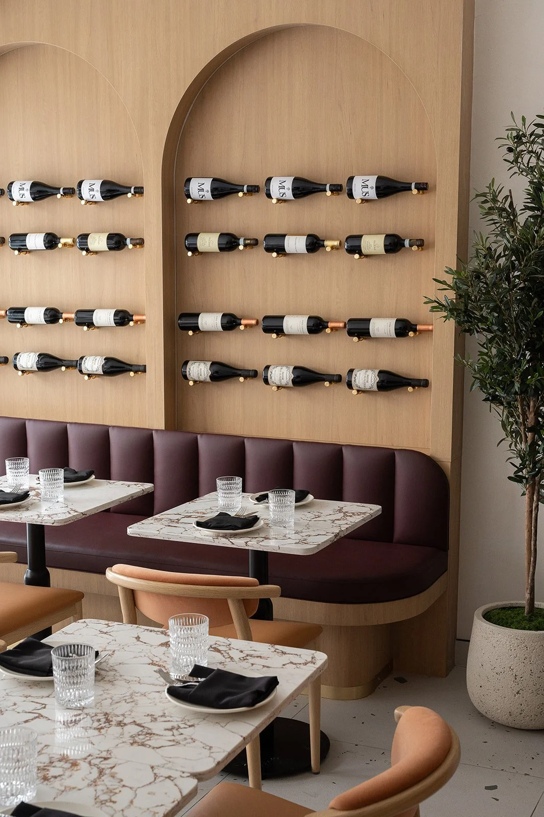 Italian restaurant banquette with wine bottle display above