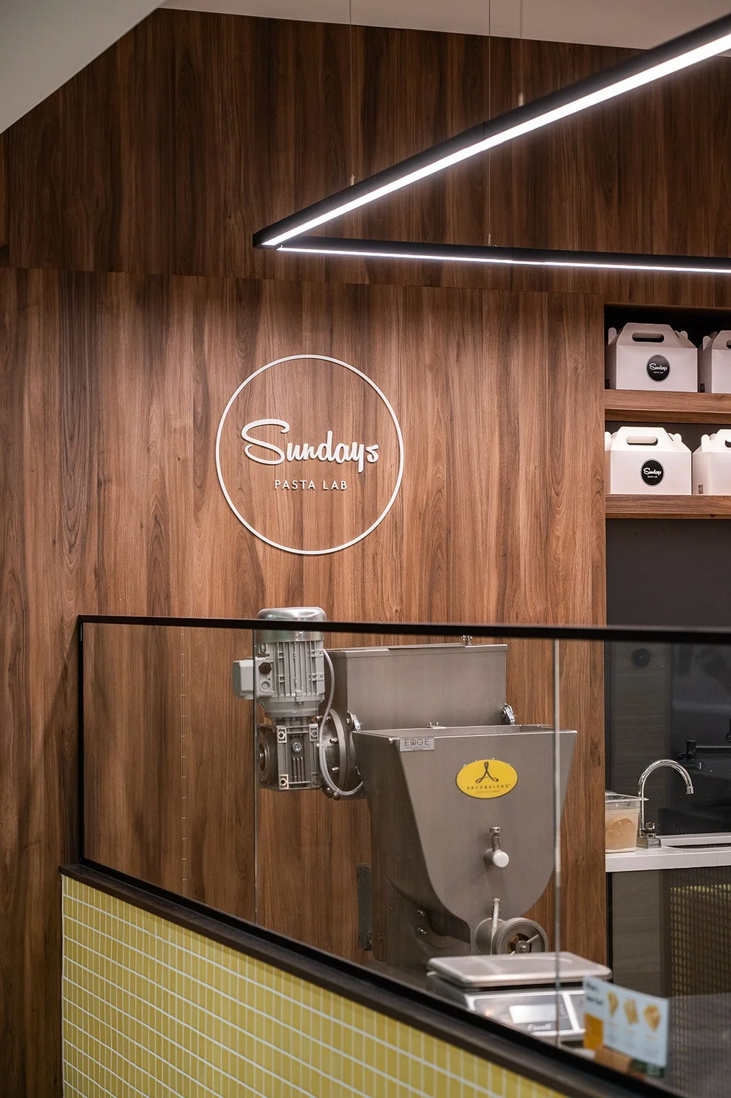 Walnut wall with Sunday's Pasta logo signage
