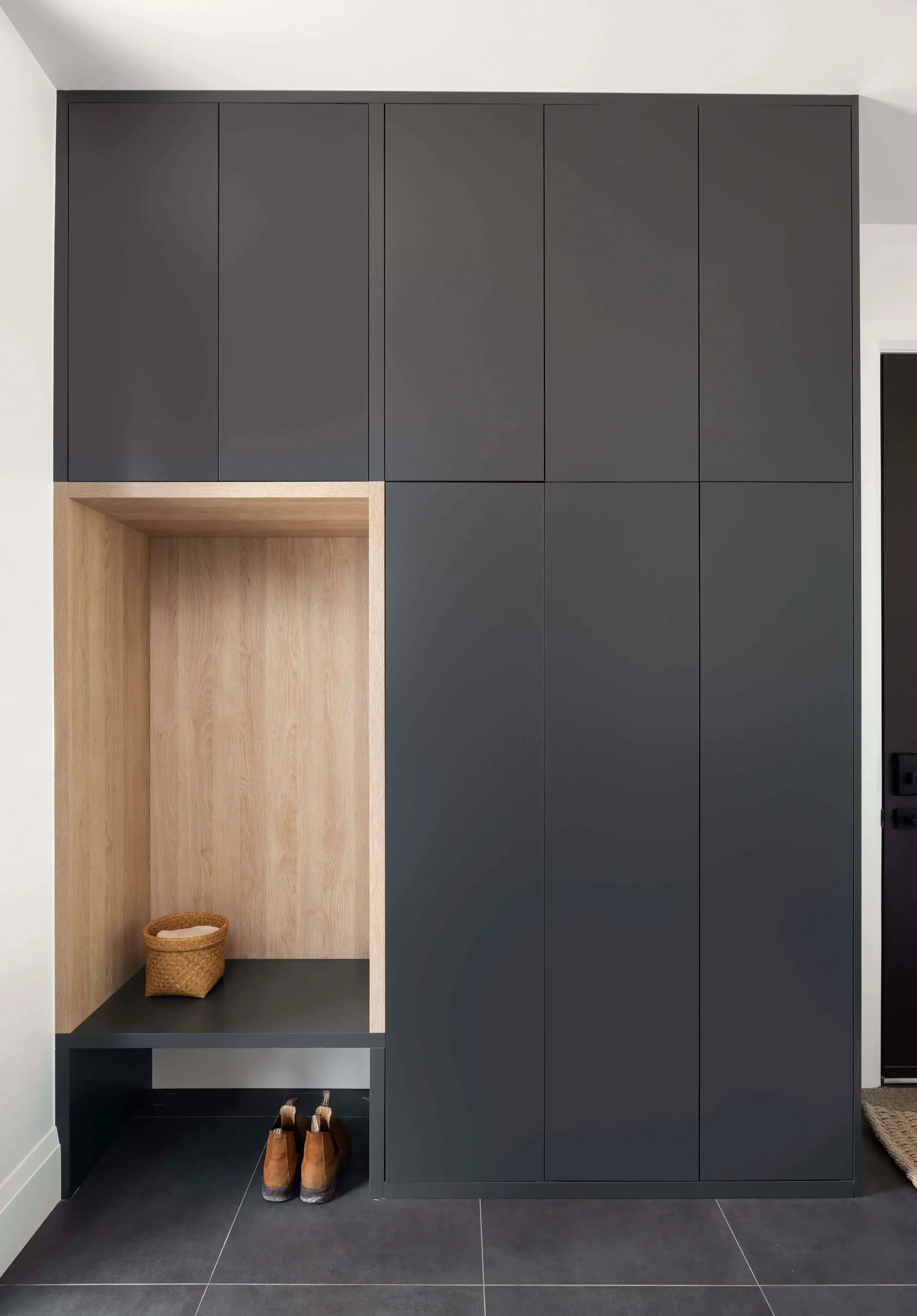 Modern foyer storage design in East Gwillimbury custom home with built-in cabinetry, wood accents, and functional entryway organization