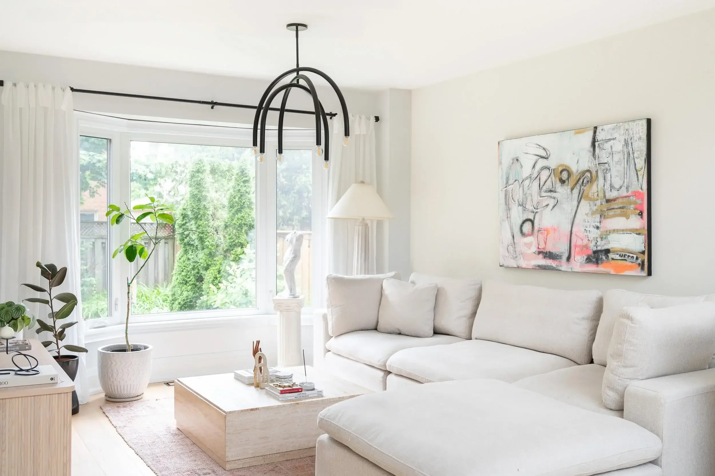 Full house renovation in Burlington featuring a bright modern living room with neutral tones and curated artwork by Sansa Interiors
