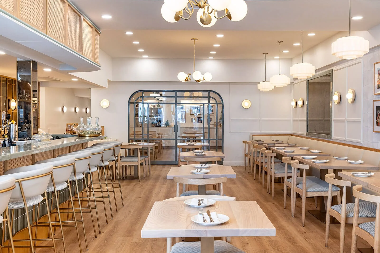 Tabule Oakville bar area — marble bar top, brass barstools, and arched millwork in a contemporary Mediterranean restaurant interior