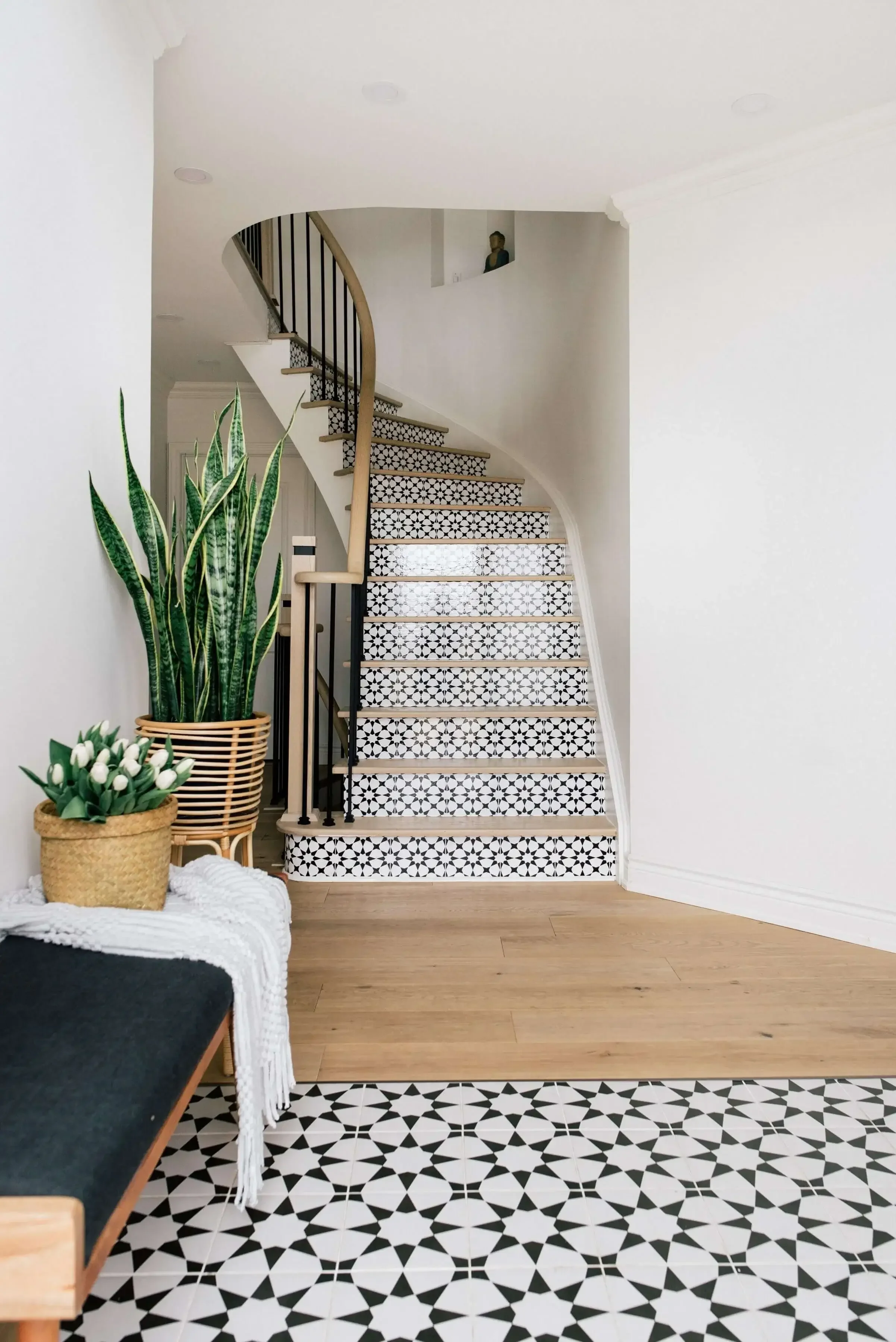Foyer staircase design in Brampton home renovation with patterned tiles, curved railing, and warm modern entryway styling
