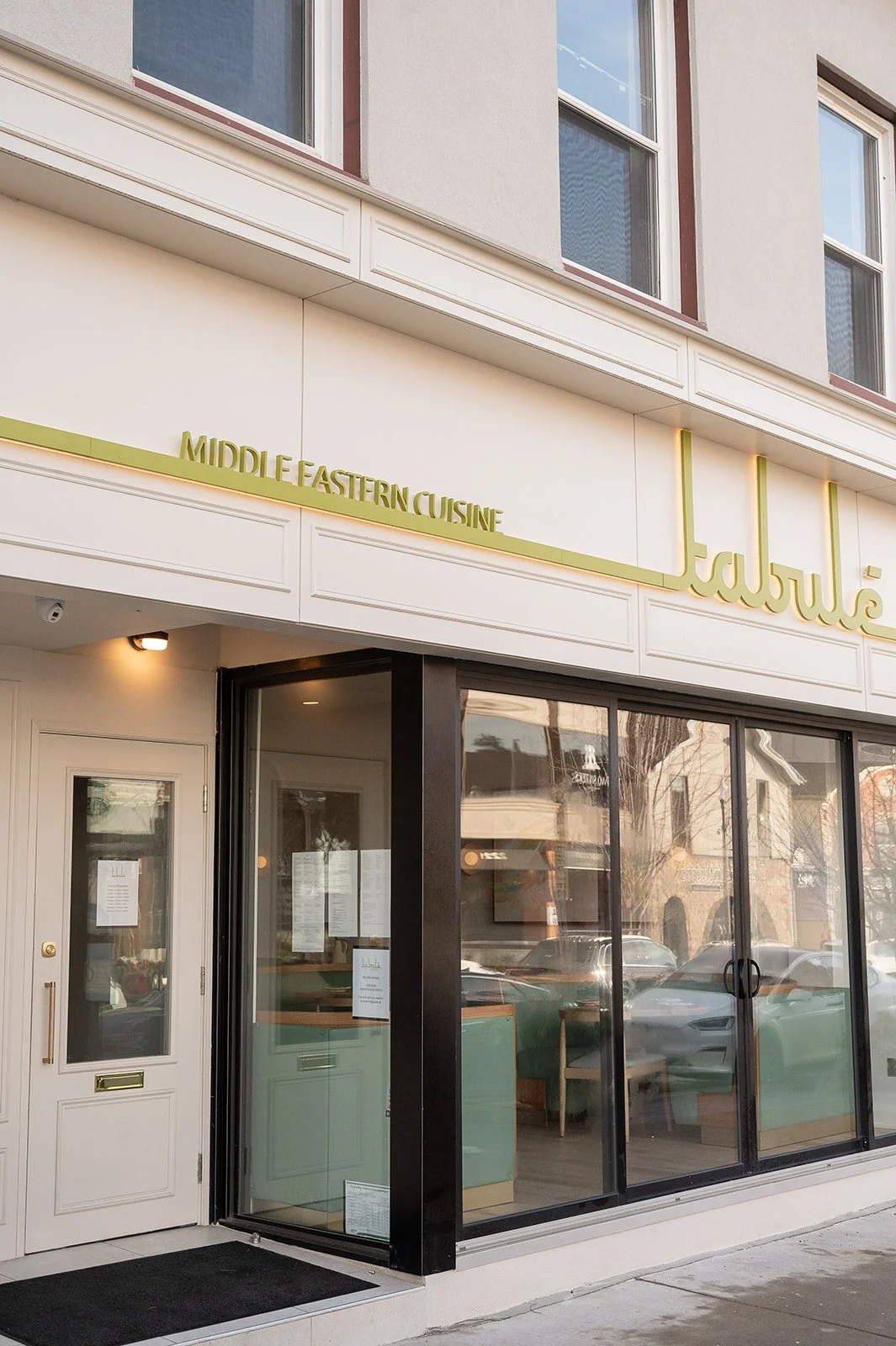 Tabule Oakville restaurant entrance with sage green fluted tile host stand and exterior view designed by Sansa Interiors