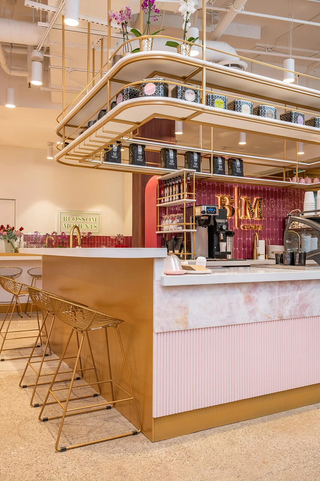 Cafe counter with pink stone and pink fluted wood and brass accents