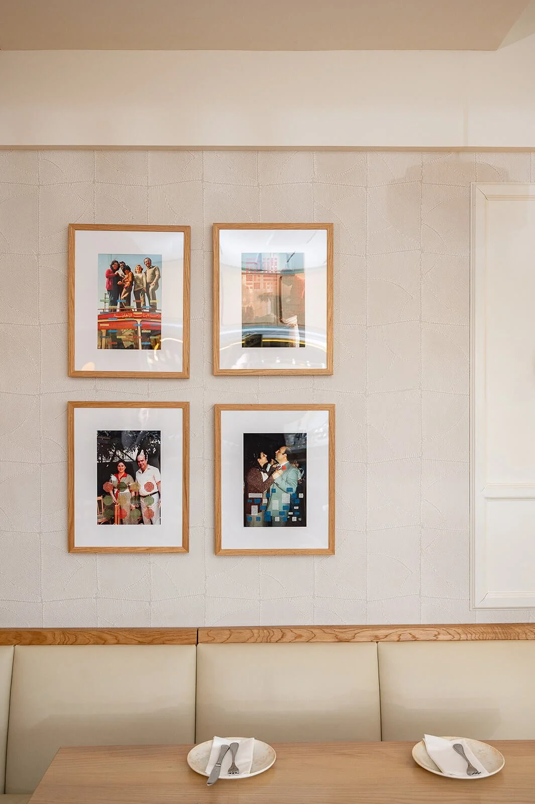 Custom artwork gallery wall in Oakville restaurant with framed photography and soft neutral interior palette