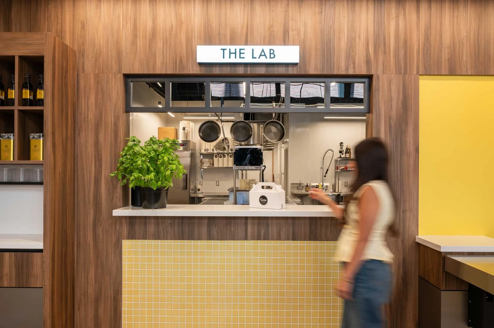 Pasta QSR pick up counter featuring yellow tile and walnut accents