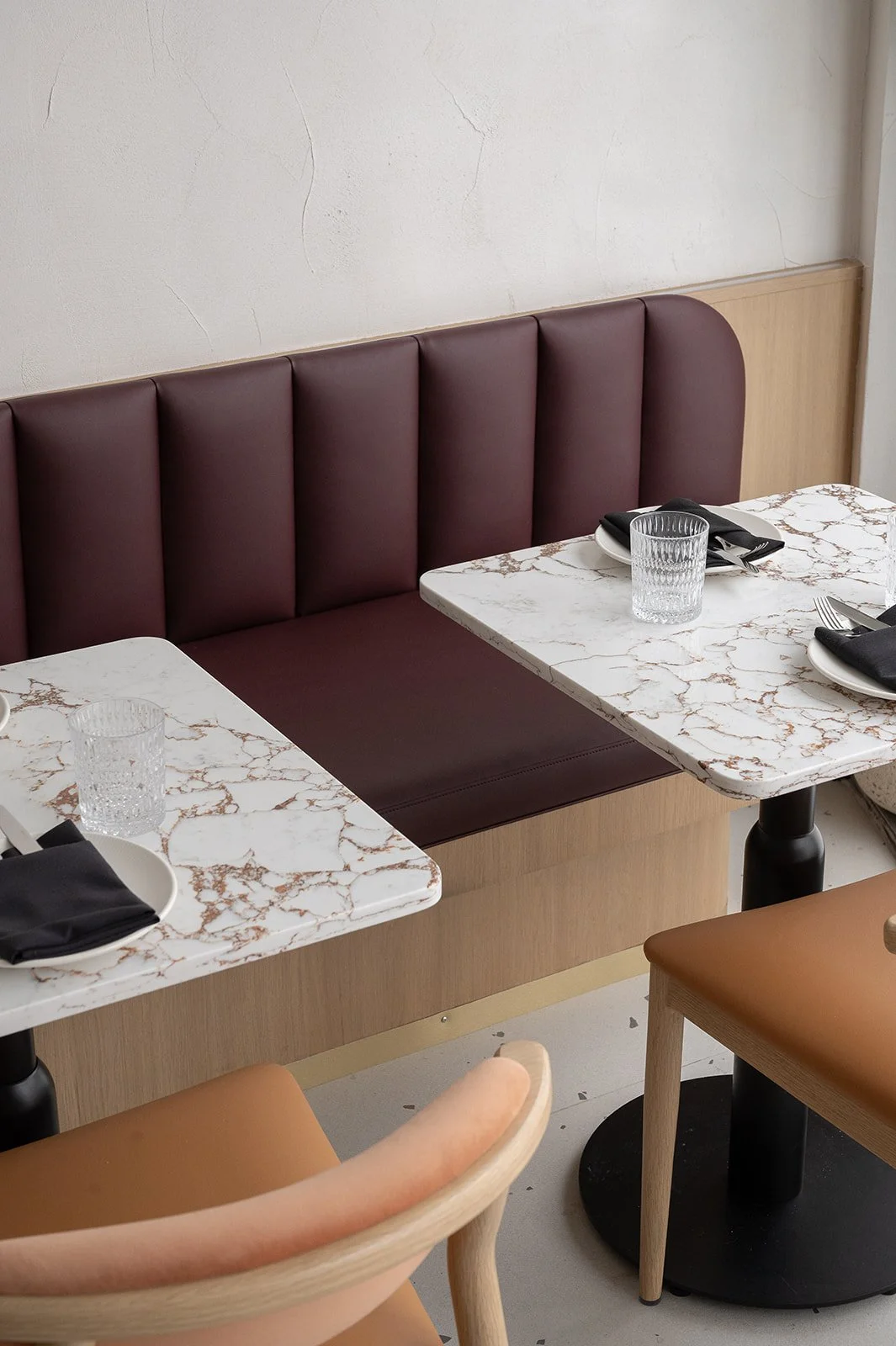 Italian restaurant banquette and 2 white quartz tables with gold veining