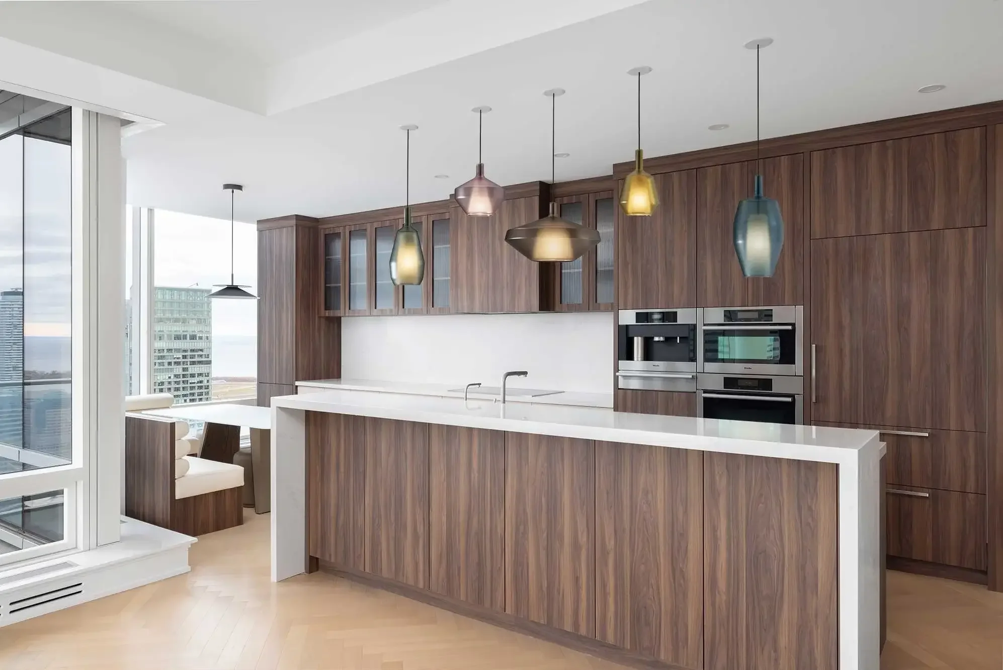 Modern organic kitchen design in Toronto condo with wood cabinetry, pendant lighting, and minimalist finishes by Sansa Interiors