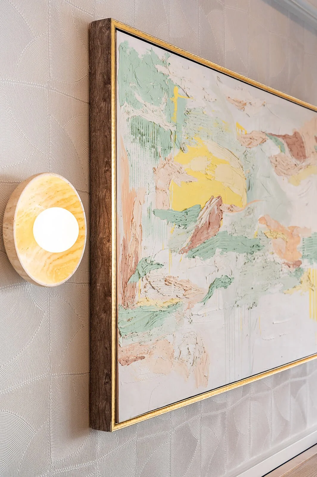 Custom artwork by Sansa Interiors in Oakville restaurant featuring abstract painting, textured wall finish, and warm wall sconce lighting