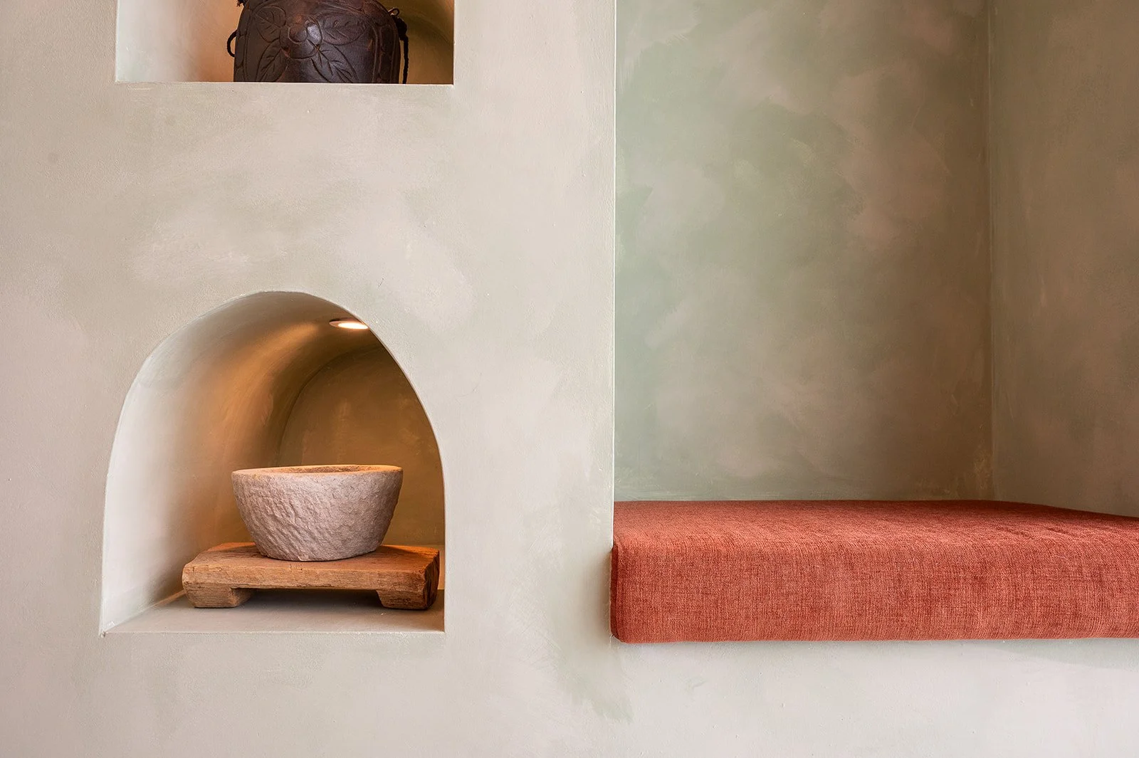 Limewash wall with arched niches featuring pottery bowl