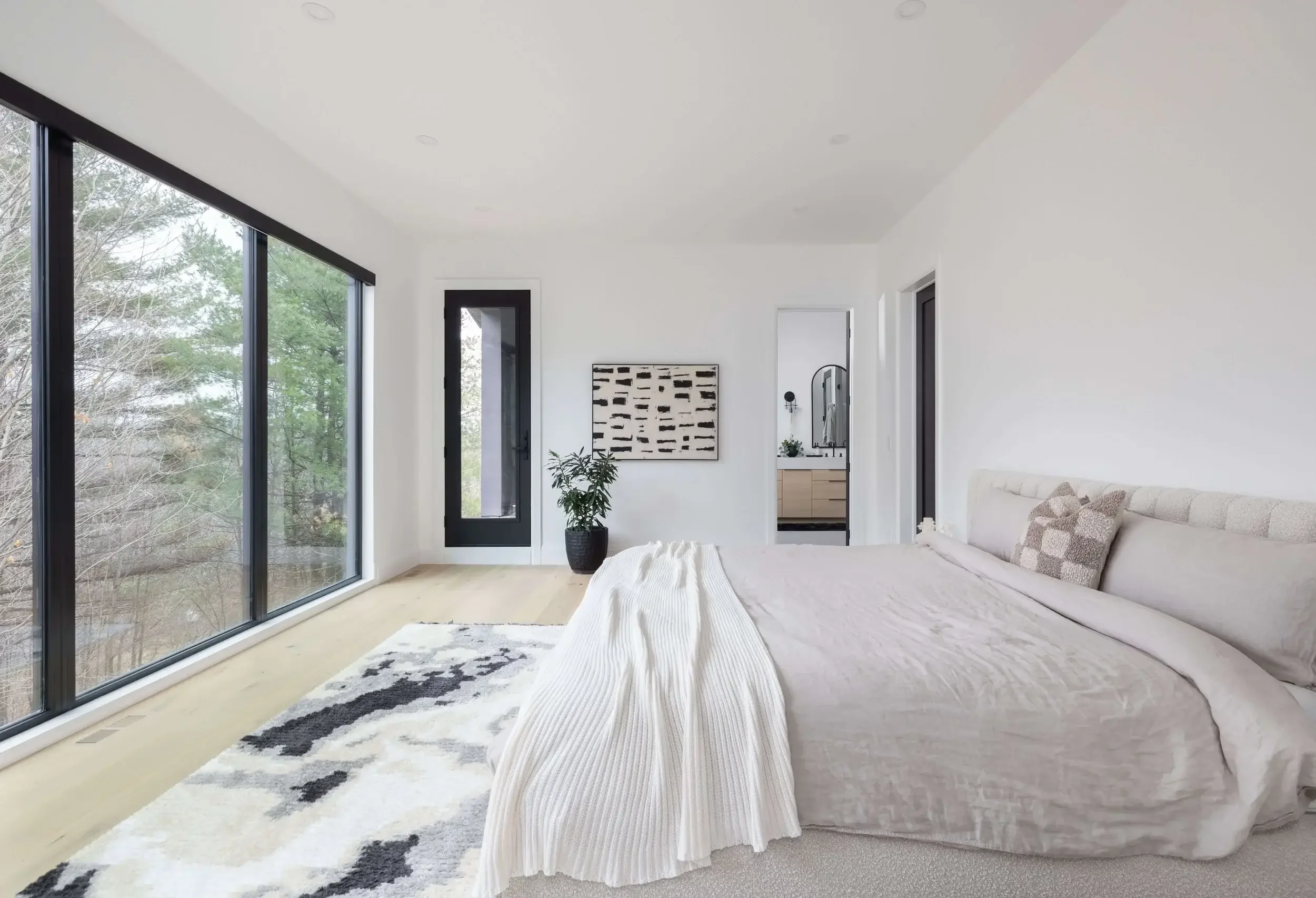 Modern bedroom interior design in Toronto custom home with large windows, neutral palette, and minimalist décor