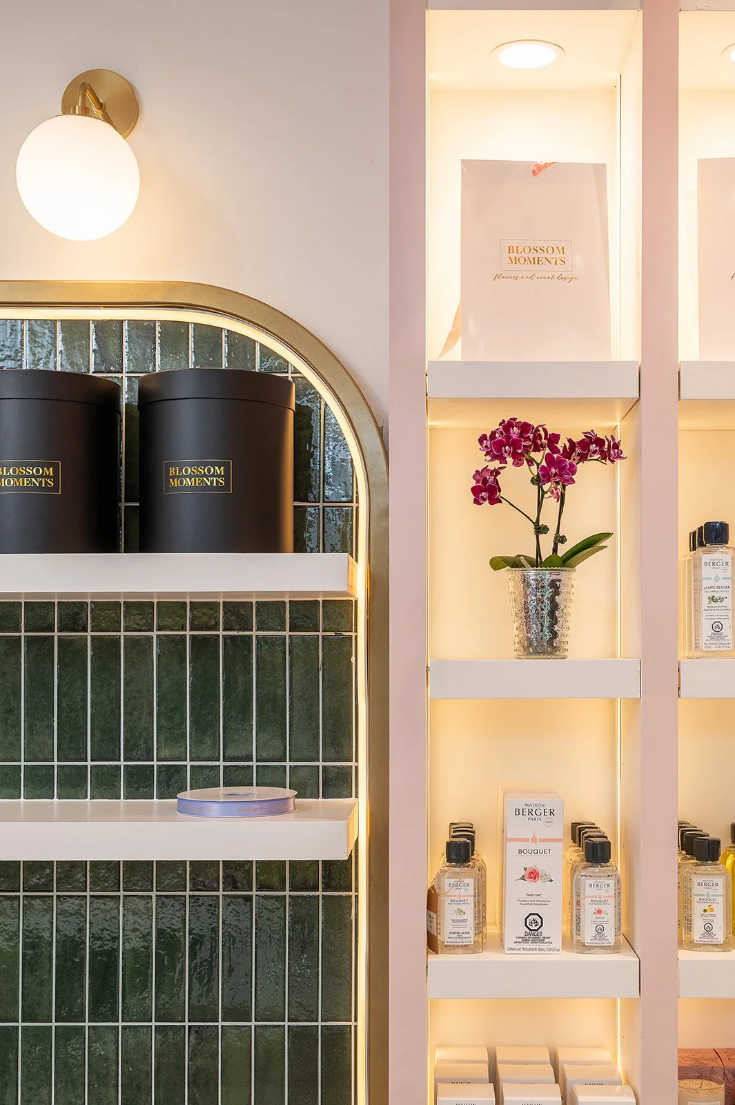 Green tile retail shelving with candle canisters and floral accents at Blossom Moments Scotia Plaza