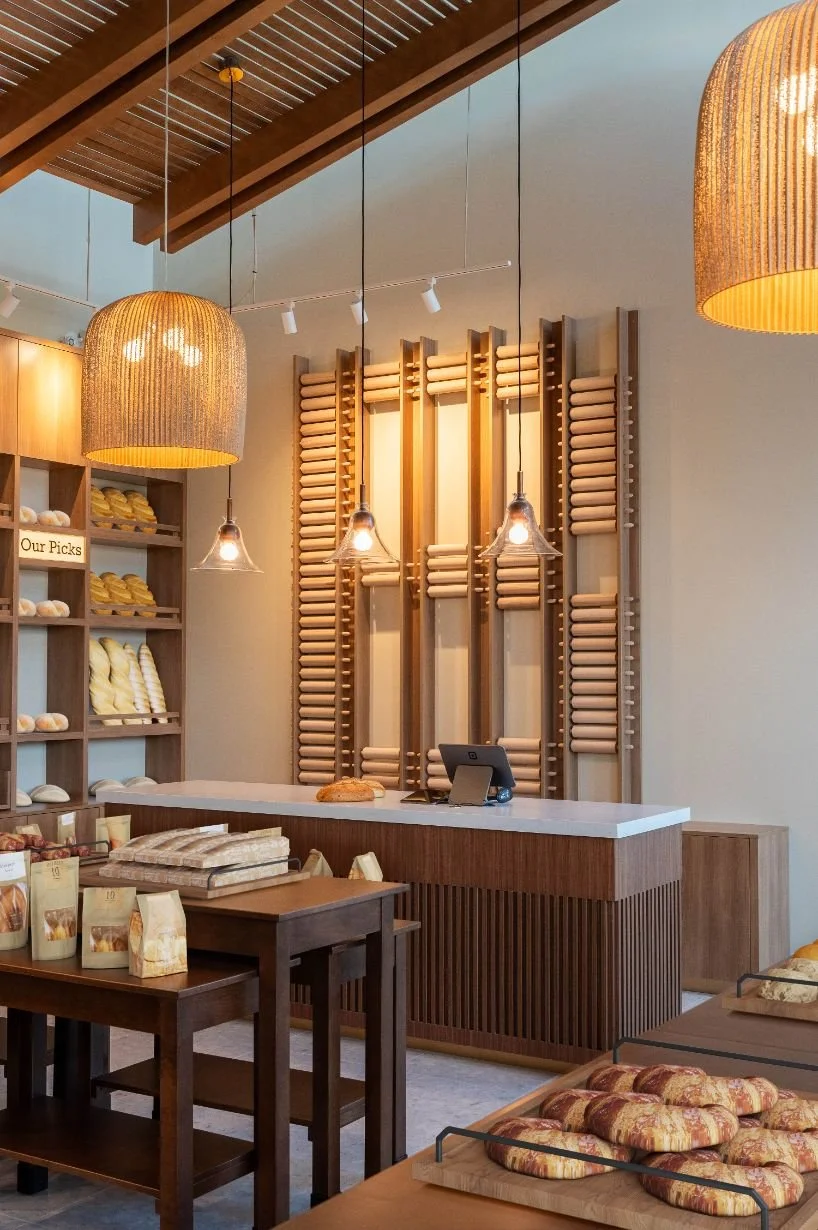 Bakery custom check out counter with wood slats with custom rolling pin wall feature behind