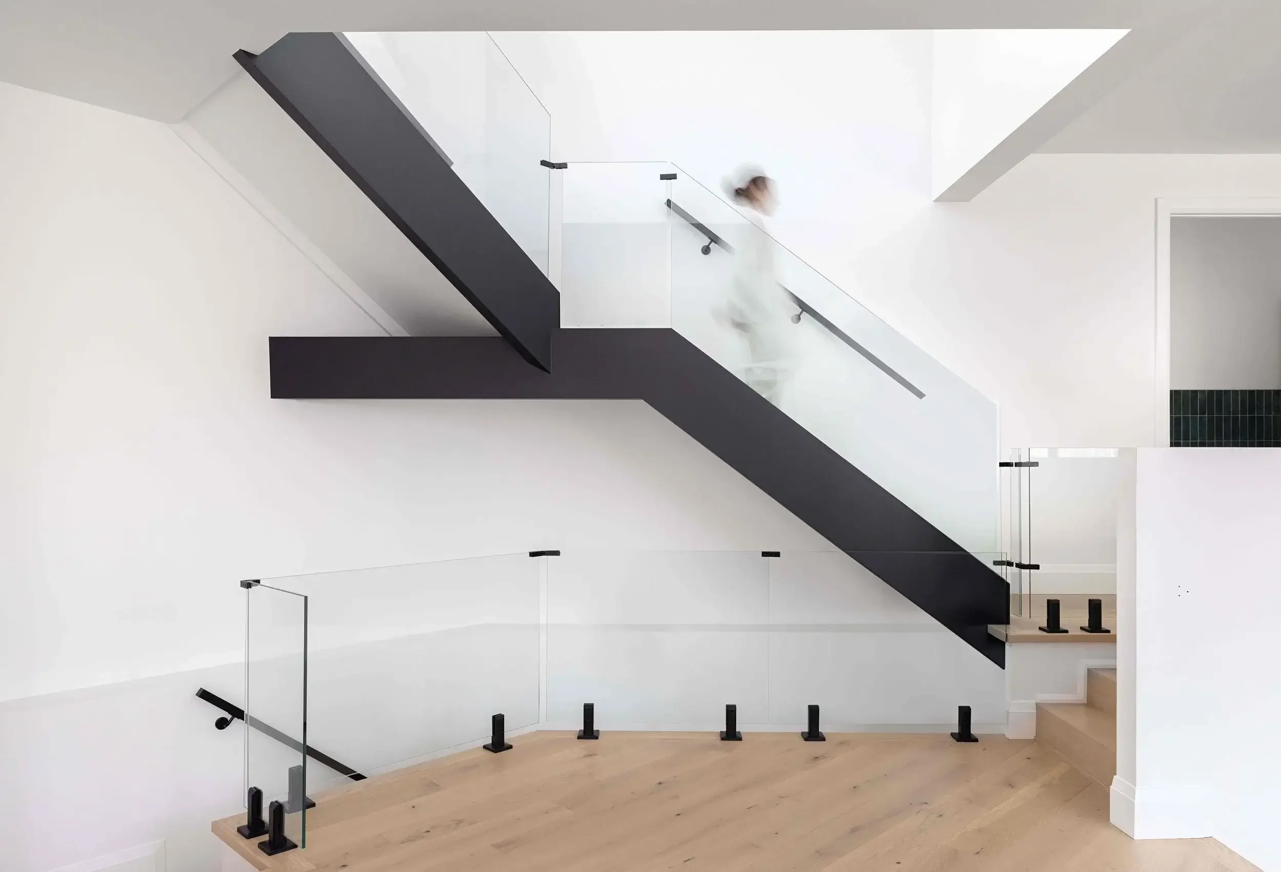 Custom home architectural staircase interior design in Toronto featuring floating stairs, glass railing, and minimalist modern layout