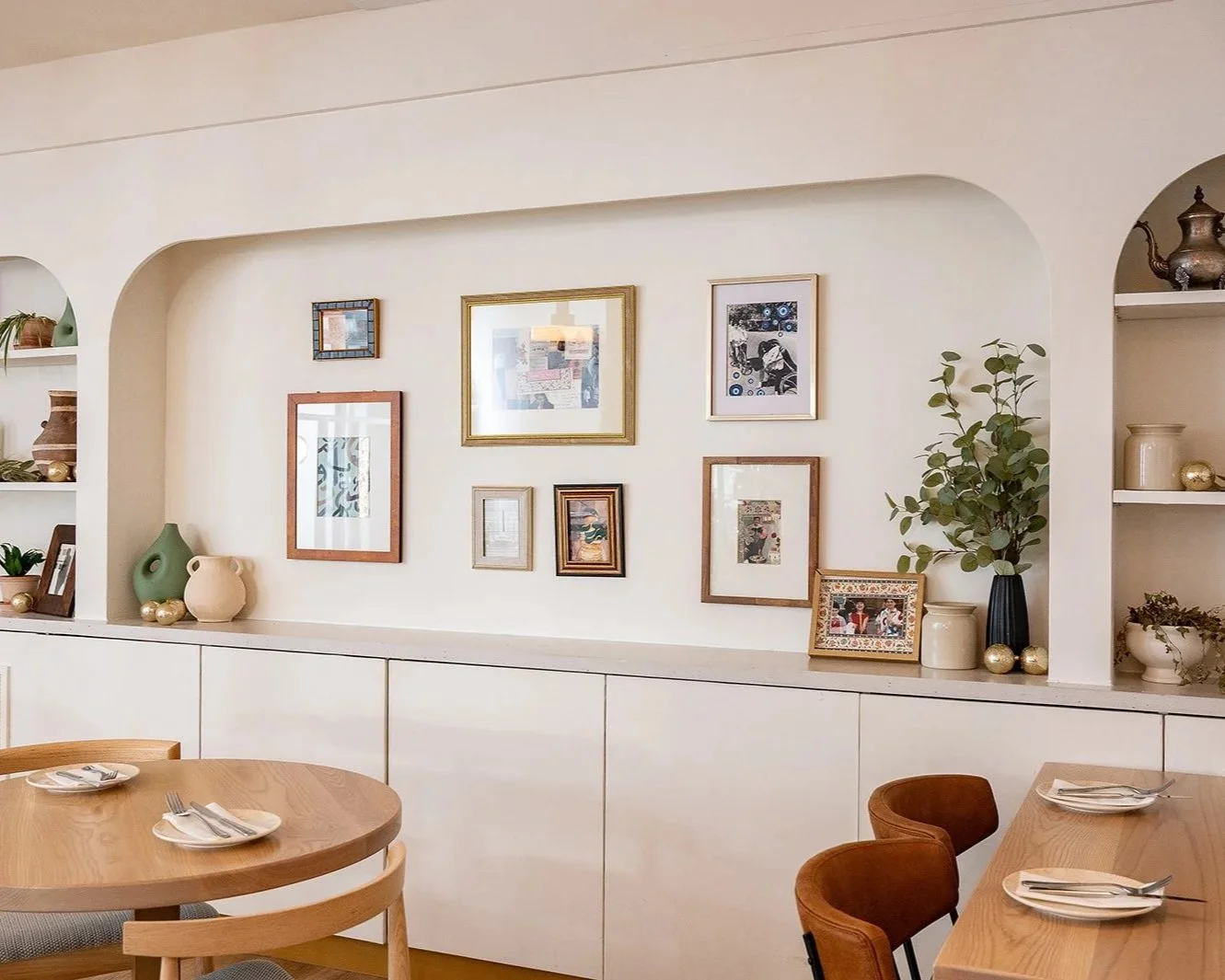 Restaurant interior design in Oakville featuring custom artwork display, arched wall niches, and warm Mediterranean-inspired styling