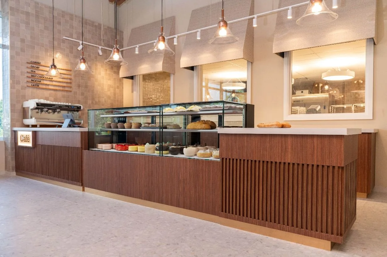 custom cafe counter with wood slats featuring 2 large display cases of desserts