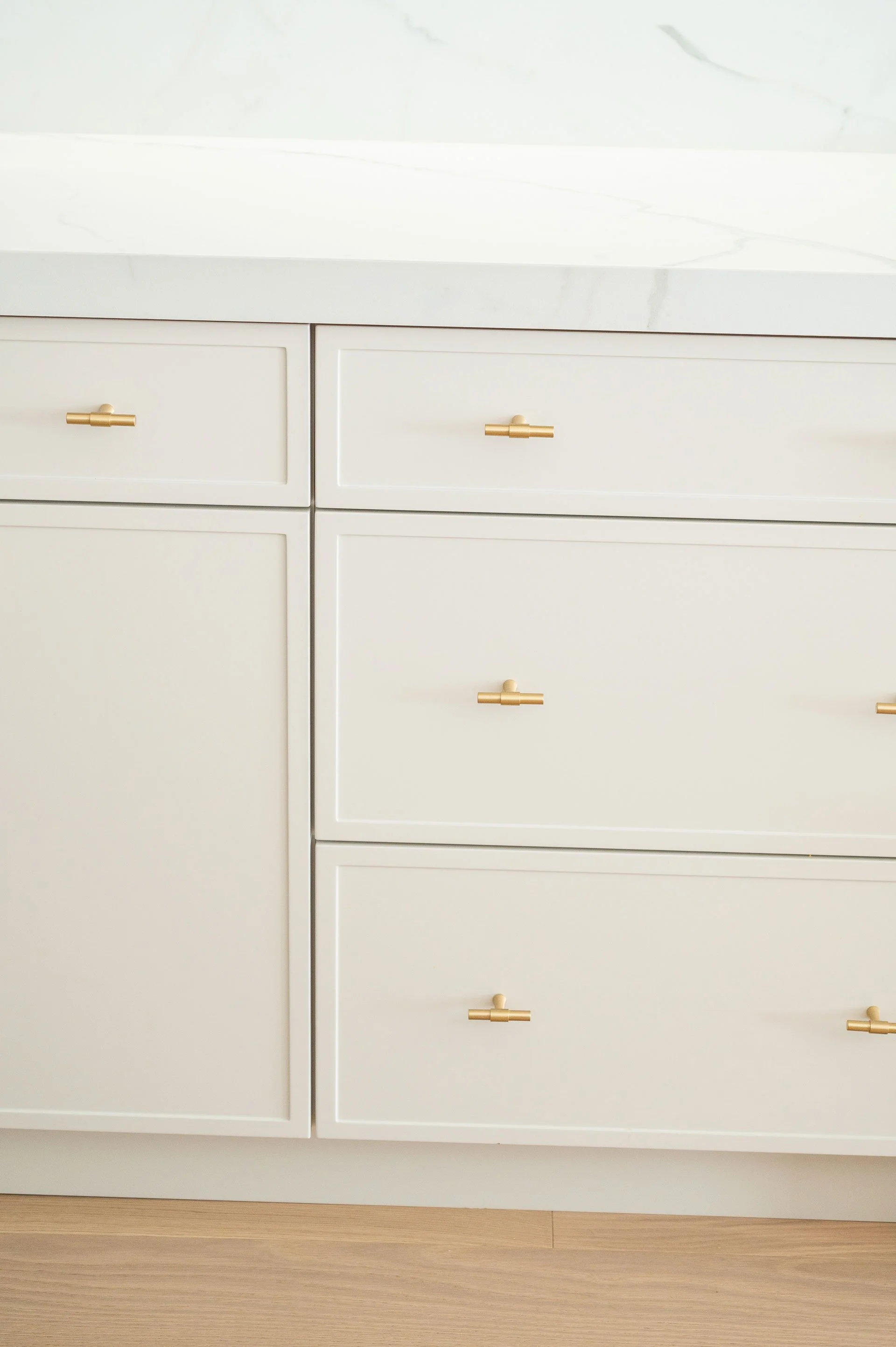 Cream slim shaker base cabinets with brass t shaped knobs