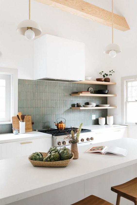 A modern white kitchen with sage green backsplash tile.