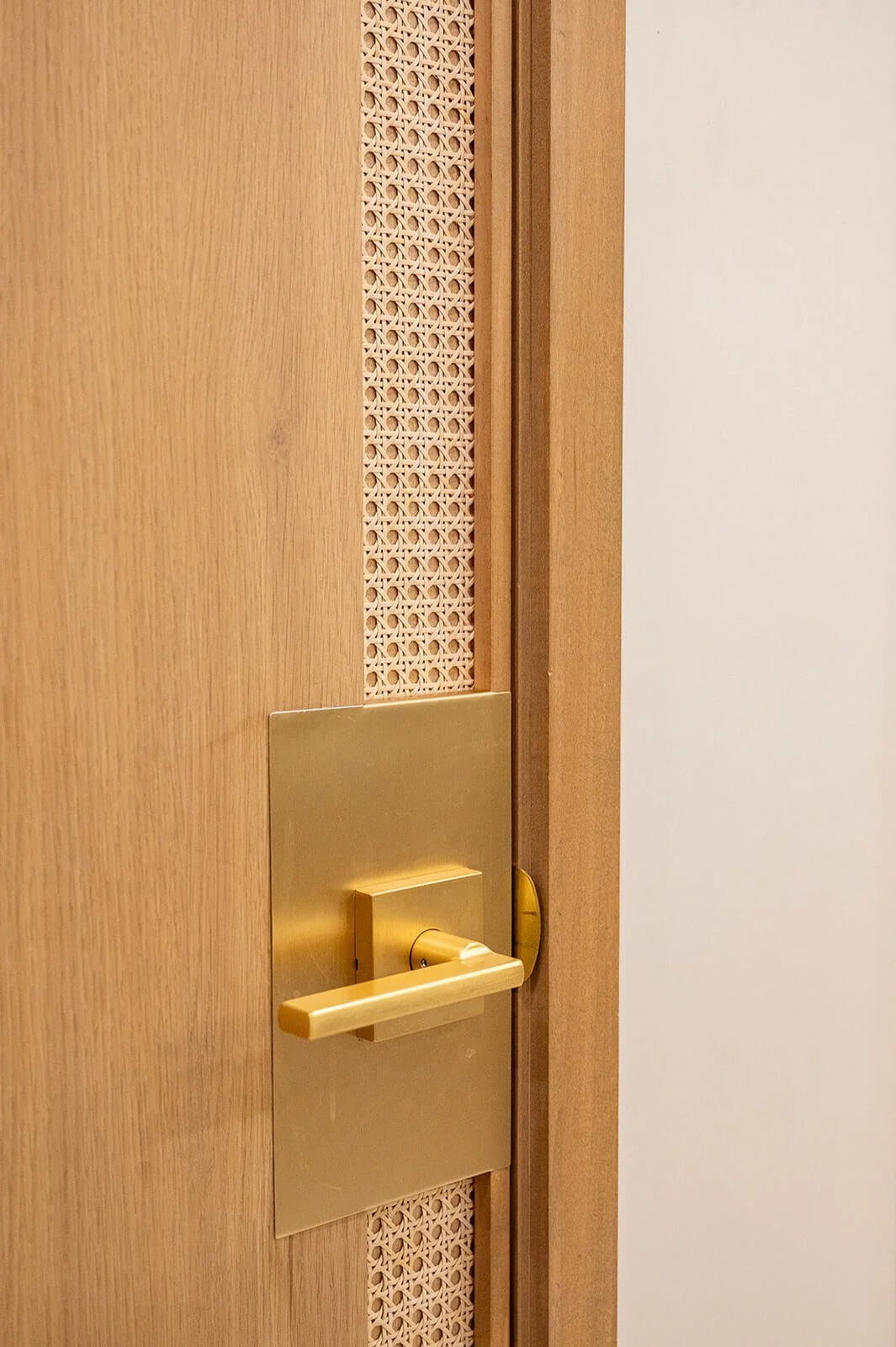 Restaurant interior detail showing brass door hardware and natural wood finishes in a modern Mediterranean design in Oakville