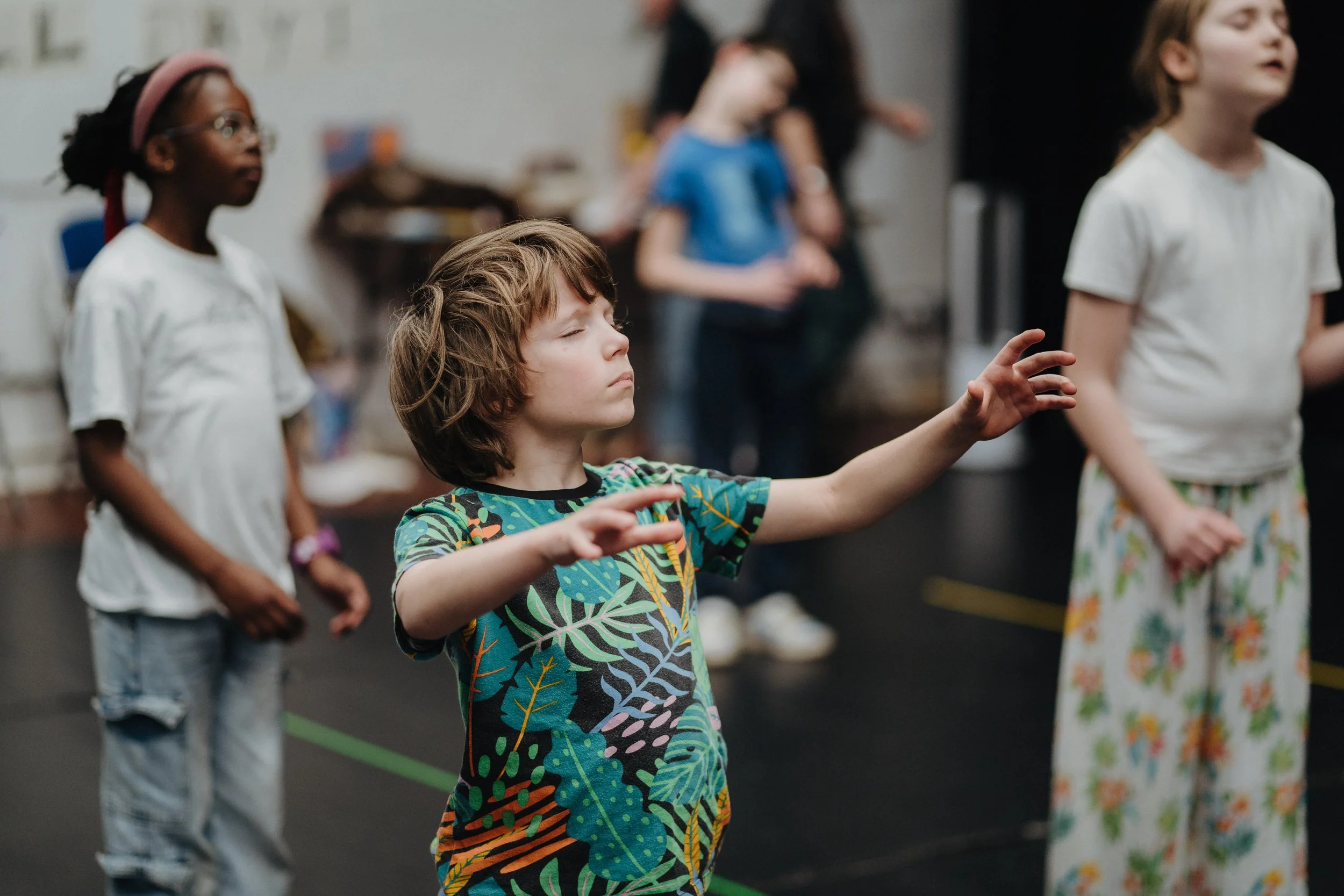 three children with their eyes closed in a dance workshop