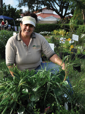 Jane poses with one of her shady combos: peperomia, coontie and spiderwort.  Photo by Tom Hewitt