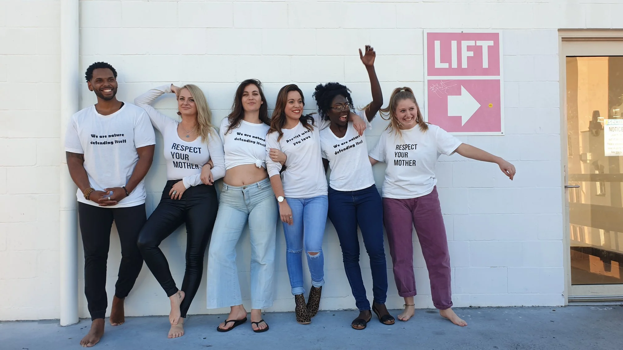 Group of people wearing 'We're All Connected' and 'We Are Nature Defending Itself' upcycled, screen-printed t-shirts with plant-based inks