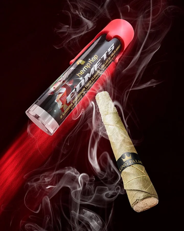 A flaming battery with smoke swirling around it, and a burning cigar with a black band that says 'King Palm'.
