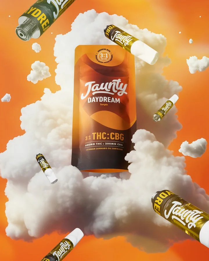 An advertisement showcasing a cannabis product called Taunty Daydream, which is a THC and CBG oil cartridge. The image features a large orange and black cartridge surrounded by white clouds and several smaller similar cartridges floating around, set 