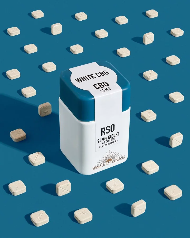 A bottle labeled 'RSO 25mg Tablets' with the text 'White CBG' and 'CBG 25mg' on a blue cap, surrounded by multiple white and beige tablets scattered on a blue background.