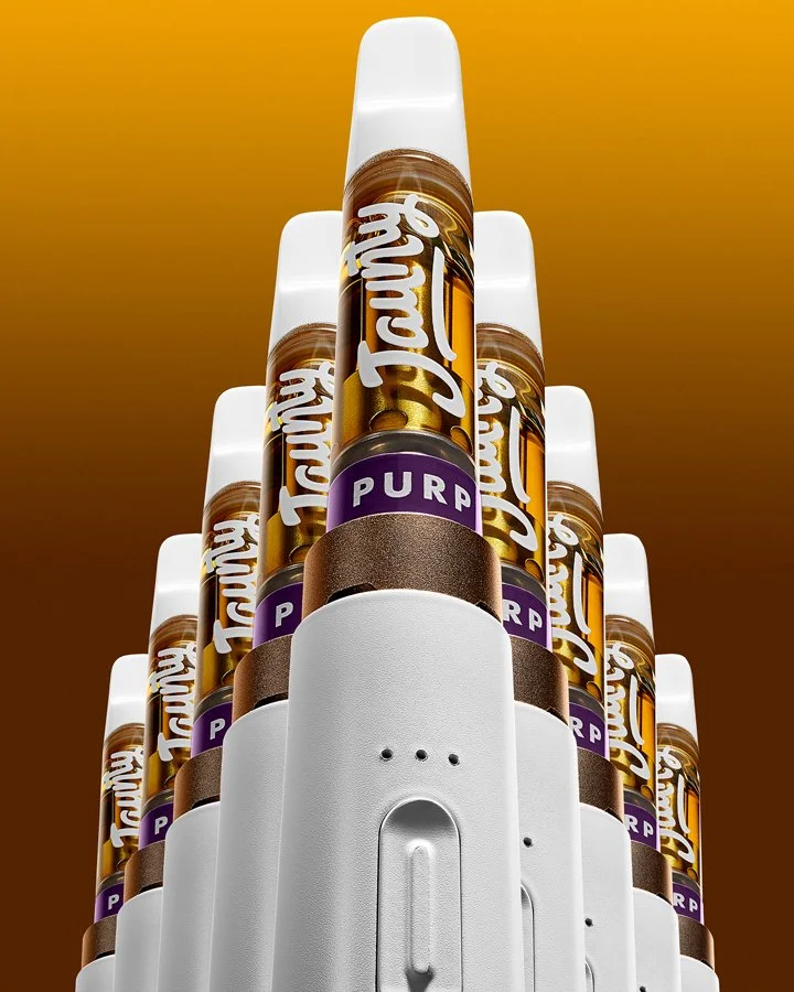 A pyramid of coffee syrup bottles labeled 'Talkin Tea' with purple labels that say 'PURP' on a white dispenser against a gradient brown to orange background.