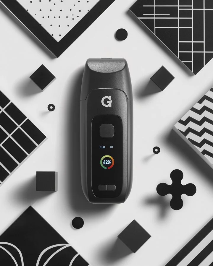 A portable vaporizer device with a digital screen displaying the temperature of 420°F, surrounded by various geometric black and white patterned objects.