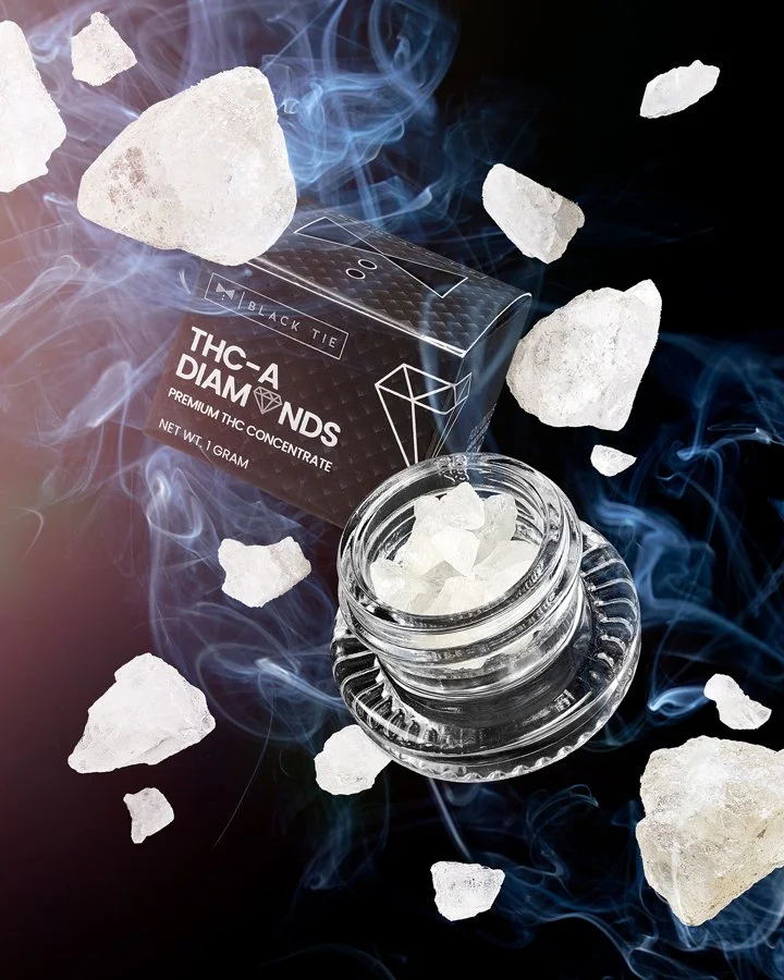 A jar filled with white crystalline rocks, a black box labeled "THC-A DIAMONDS" with a diamond graphic, and several large white crystals floating around with blue smoke-like effects.