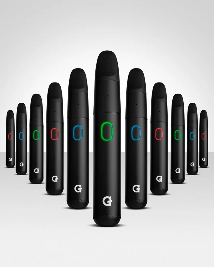 Multiple Google Pixel Stylus pens arranged in a zigzag pattern, with black bodies and multicolored illuminated rings in green, blue, and red near the top, on a plain light background.