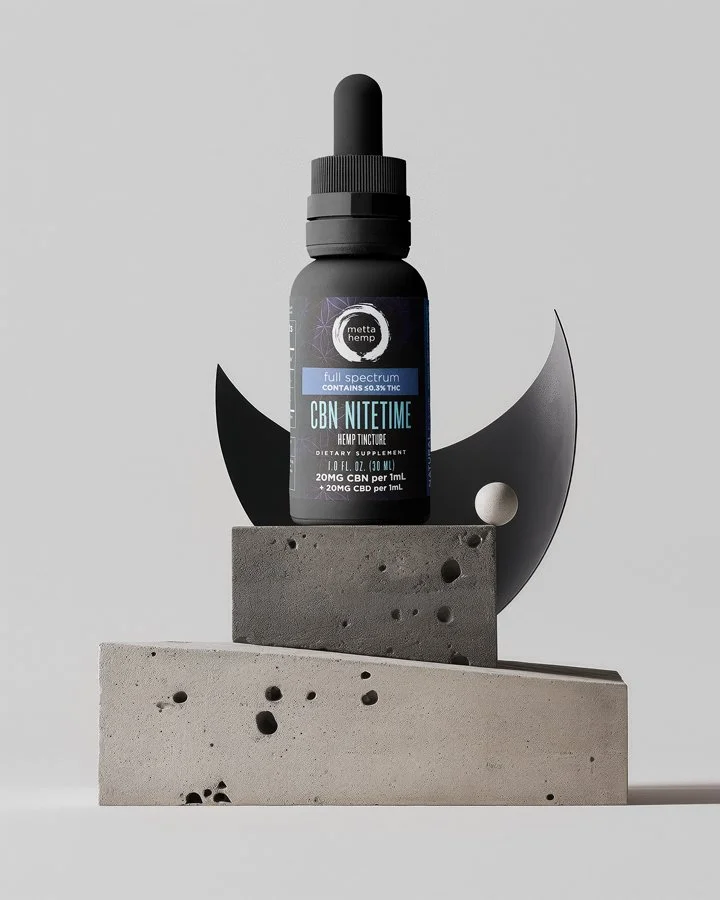 A bottle of Metta Hemp CBD nitetime tincture with full spectrum contains 0.3% THC, placed on geometric concrete blocks with abstract black shapes around it on a gray background.