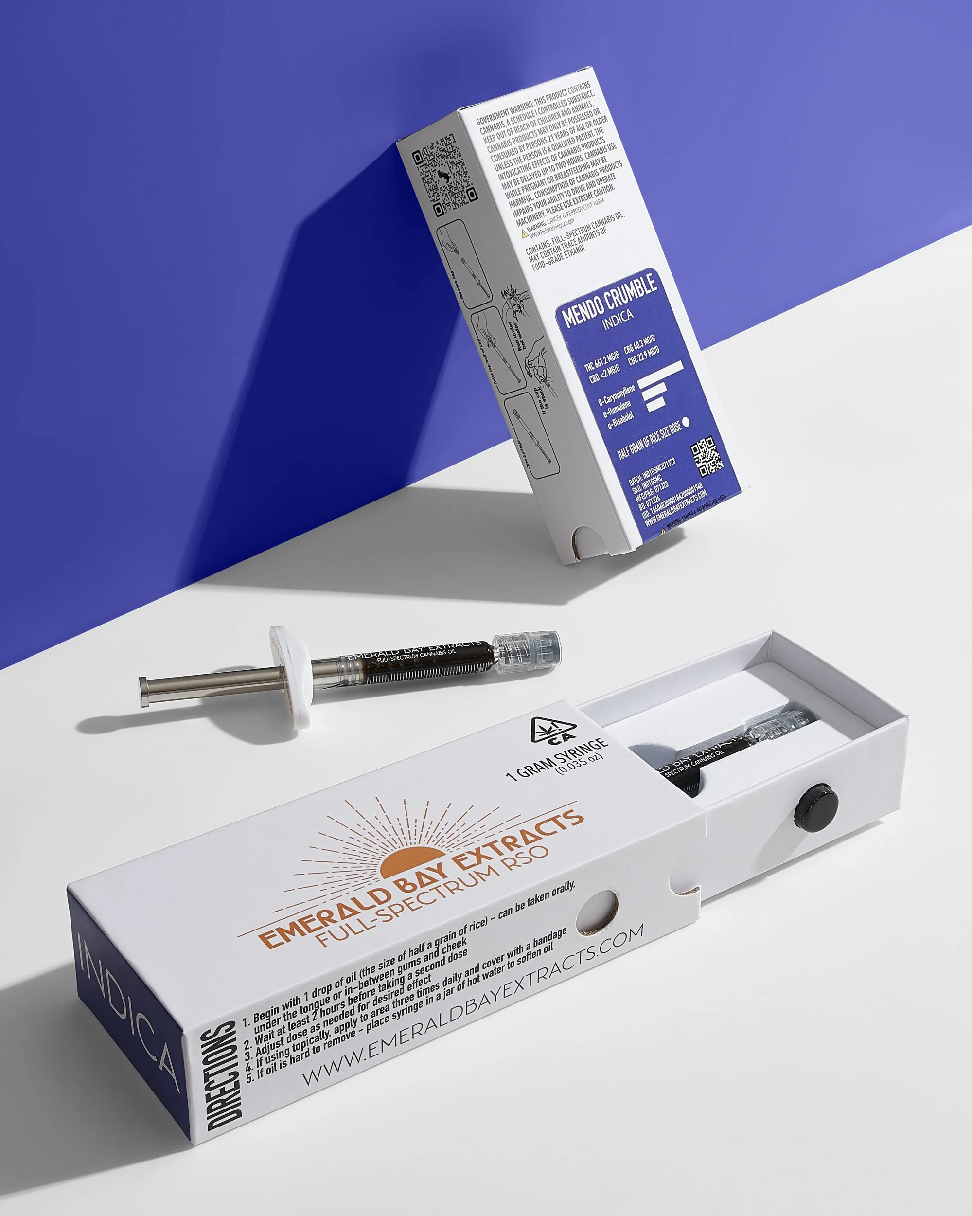 Emerald Bay Extracts - Mendo Crumble RSO Oil and packaging, white surface, blue background_.jpg