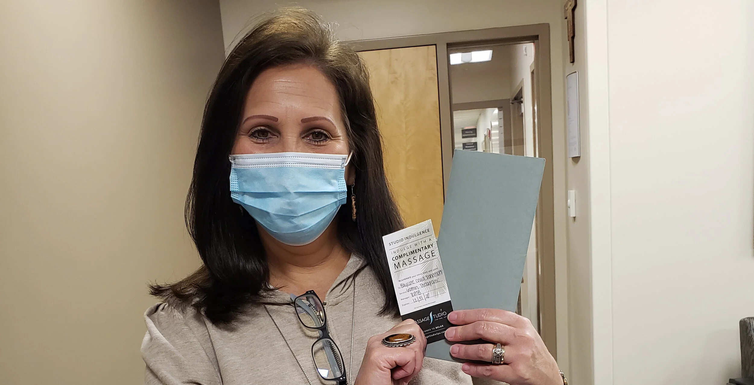 A healthcare worker is pictured with a massage voucher