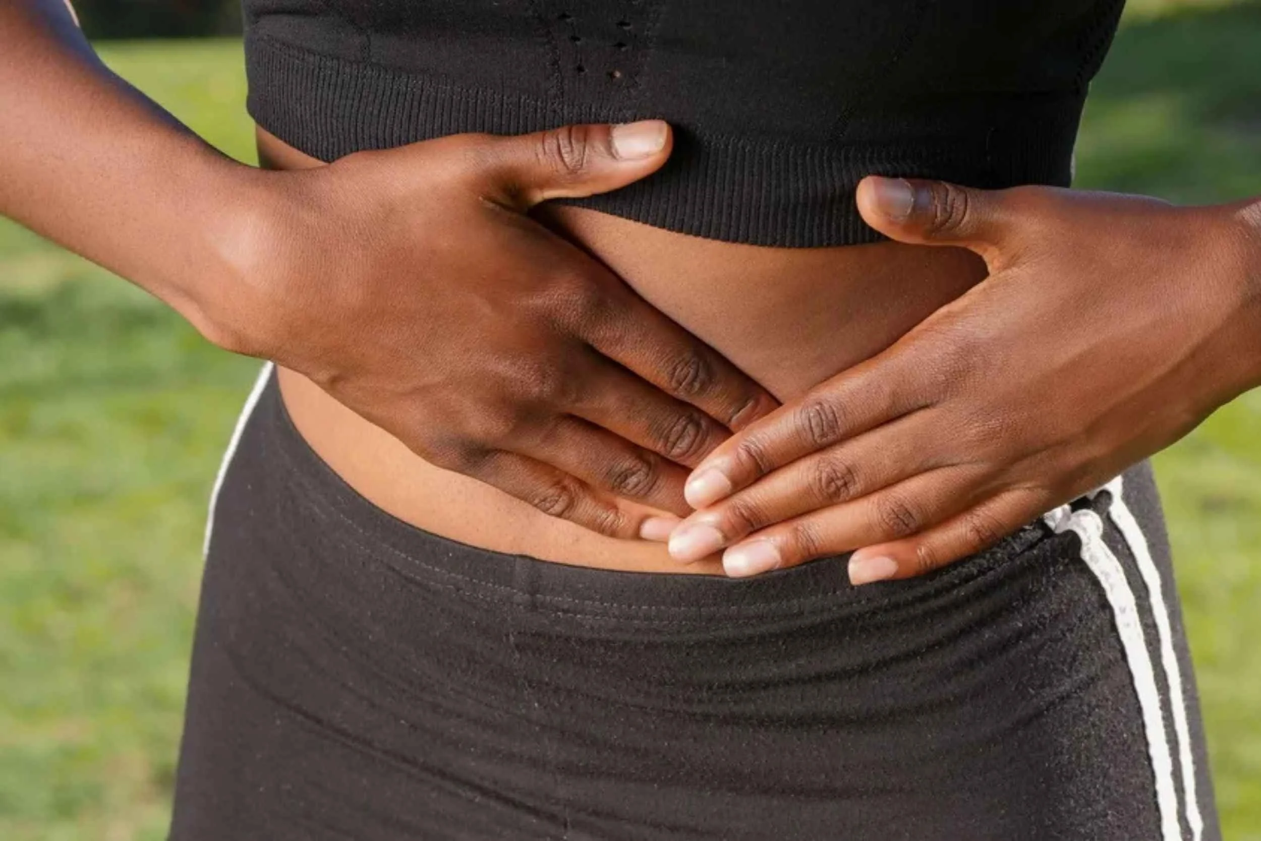Massage can help relieve symptoms of PCOS, so a woman places her hands on her abdomen