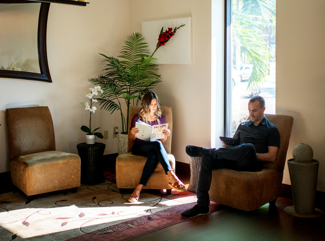Two office workers wait for a massage to decrease muscle tension and boost productivity