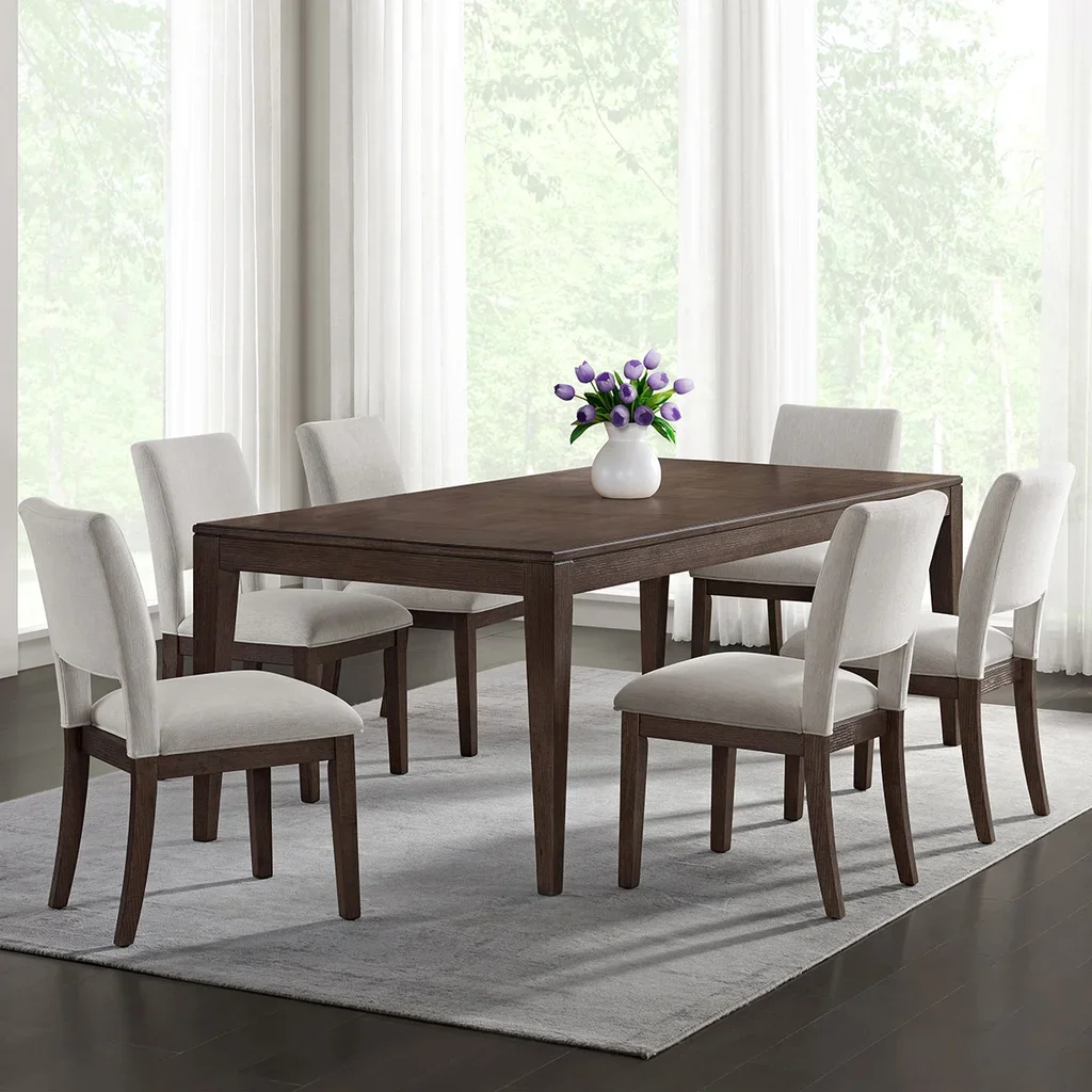Image of a brown wood dining table with six matching chairs, and a vase with purple flowers as decor.