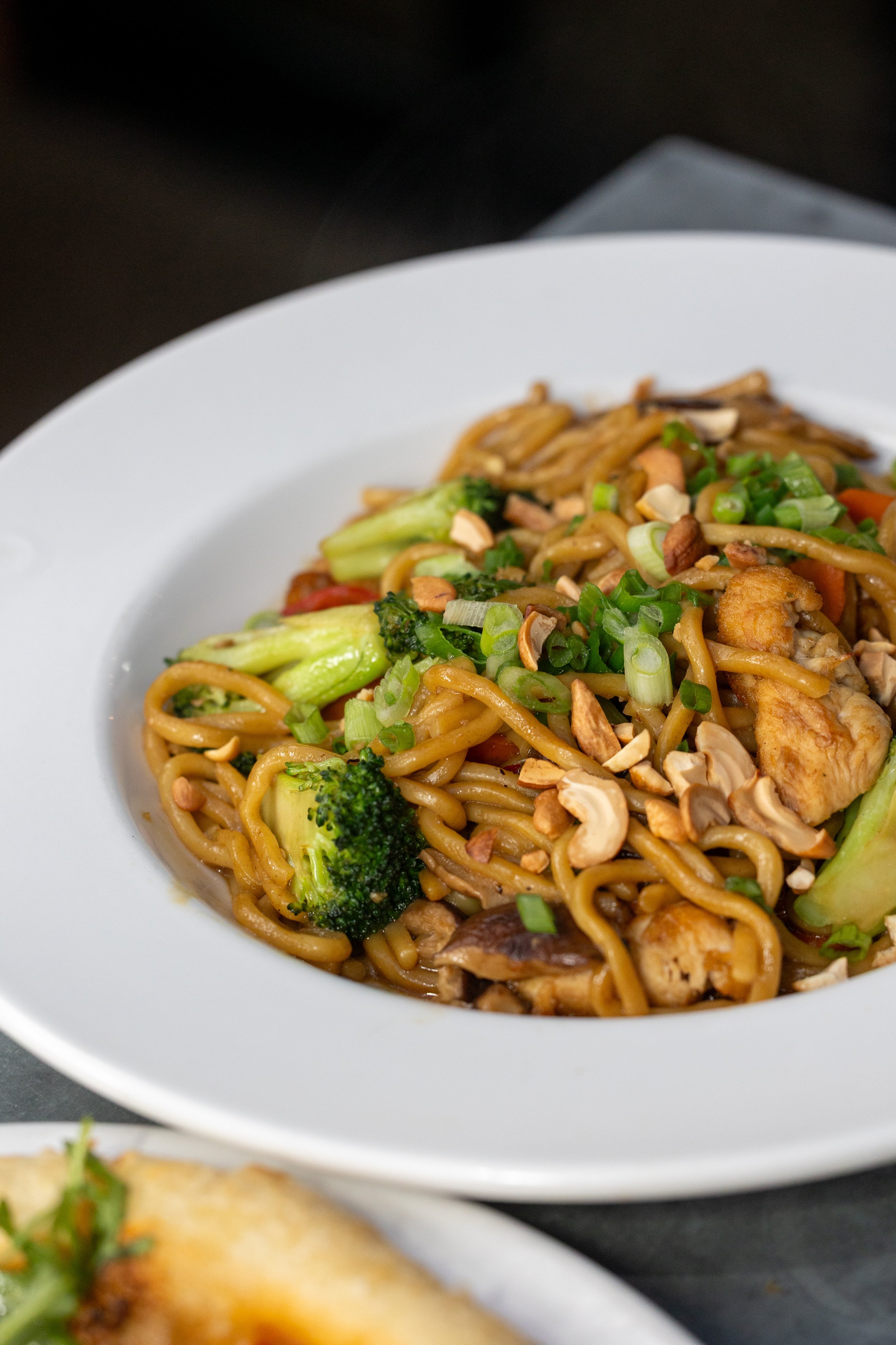  Stir fry plate with marinated chicken and mixed vegetables, topped with green onion and cashews 
