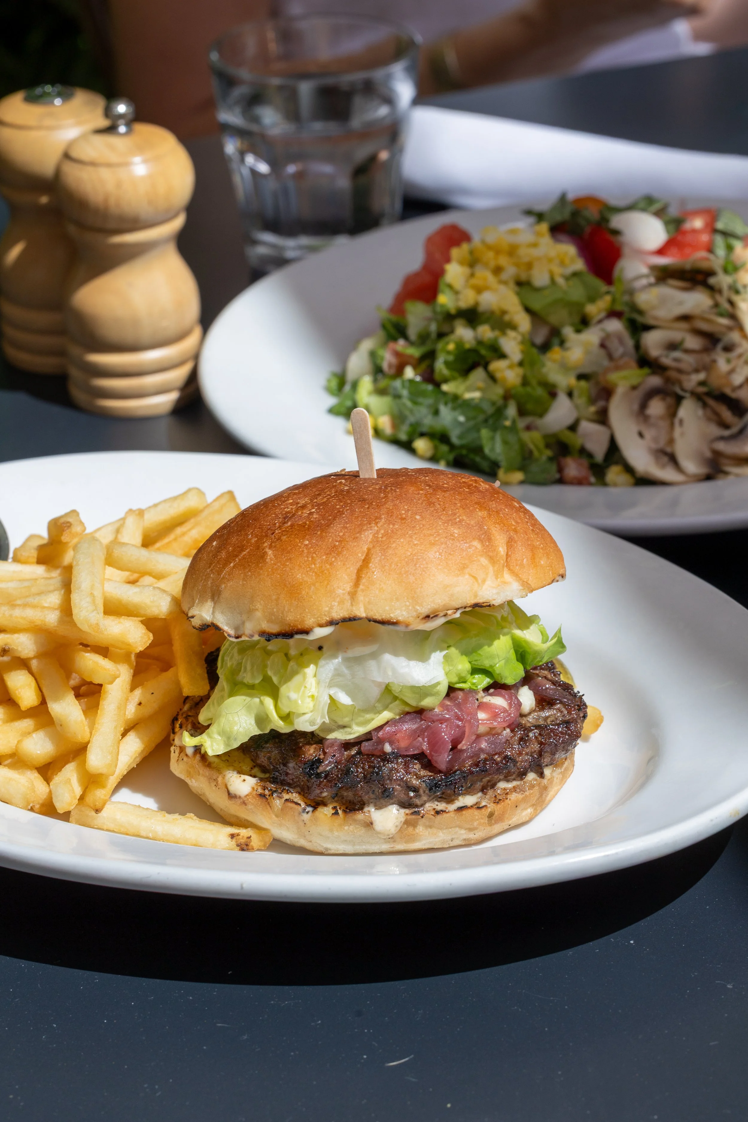  Plate with French fries and burger dressed with mayonnaise, lettuce, blue cheese, and caramelized onion 