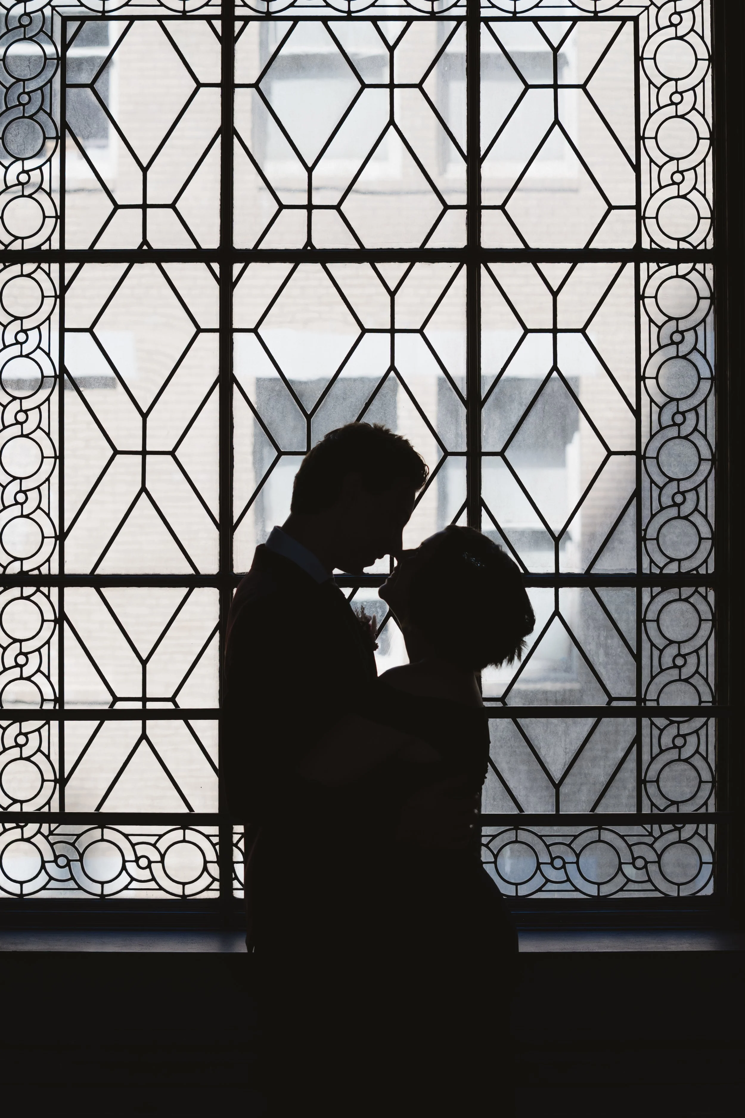 Couple silhouetted against a City Hall window