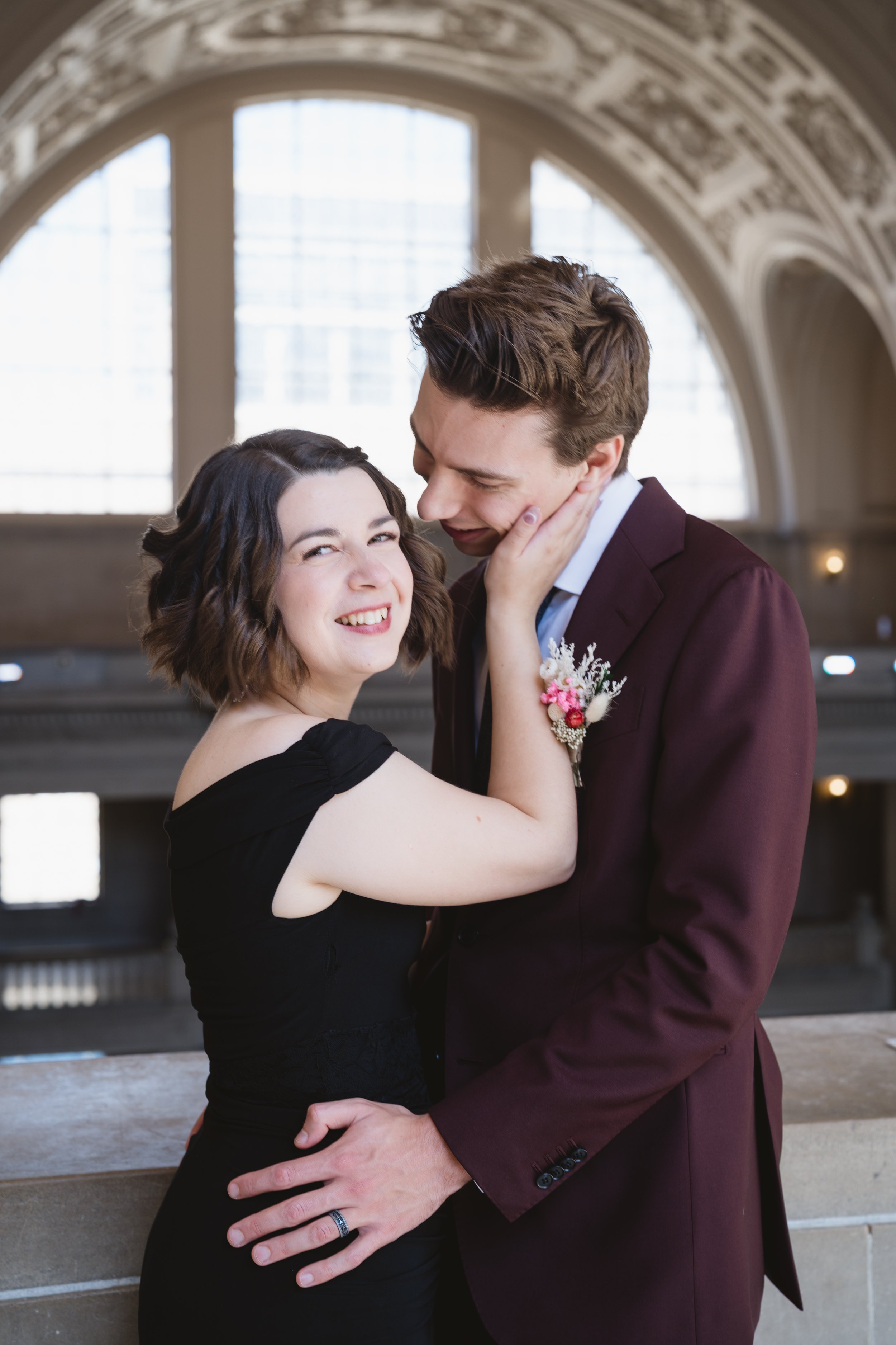 Smiling bride and groom by the rotunda's arched windows